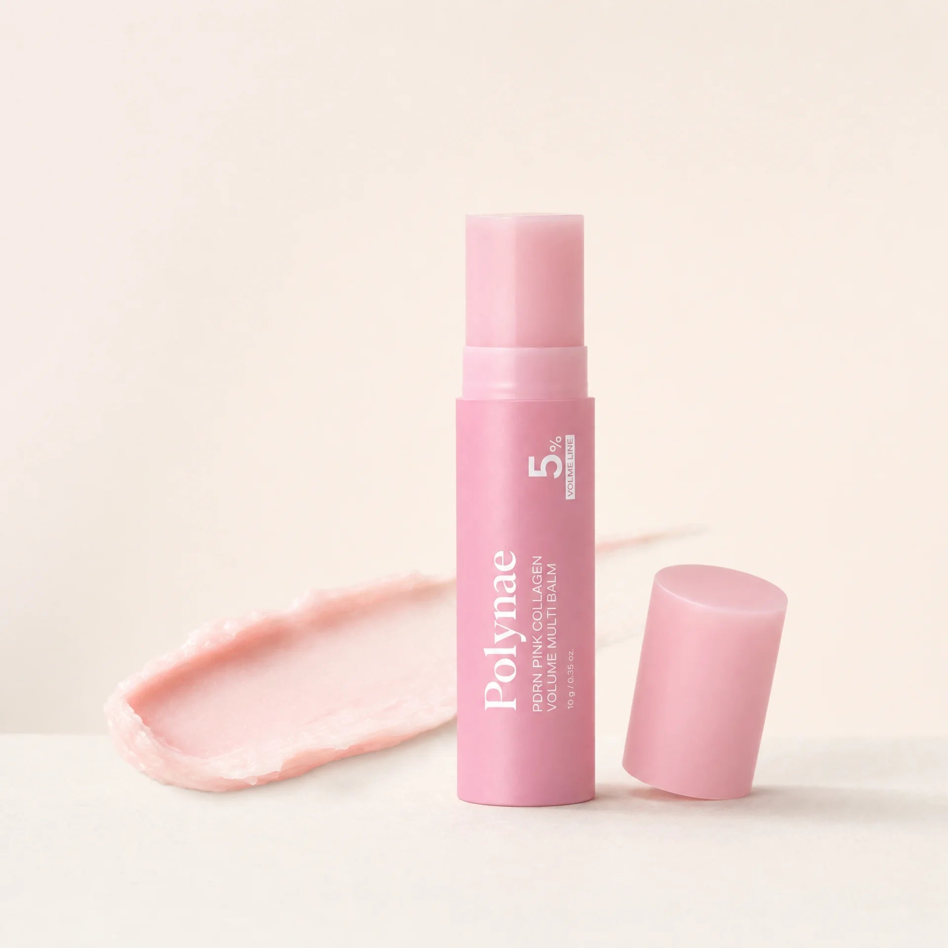 CureRox PDRN Collagen Volume Multi Balm stick, upright with cap removed beside a balm swatch